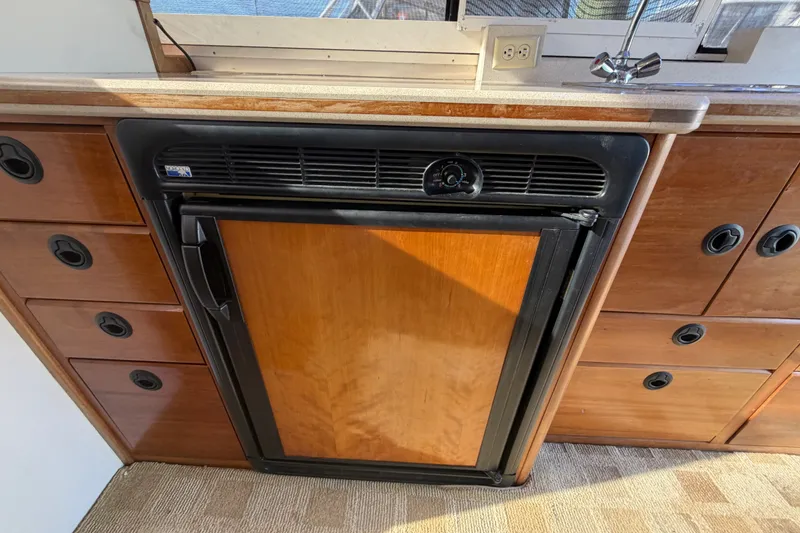 Slide: The Image of 2000 Albin 35 Tournament Express interior with wooden cabinetry and compact refrigerator. - 27