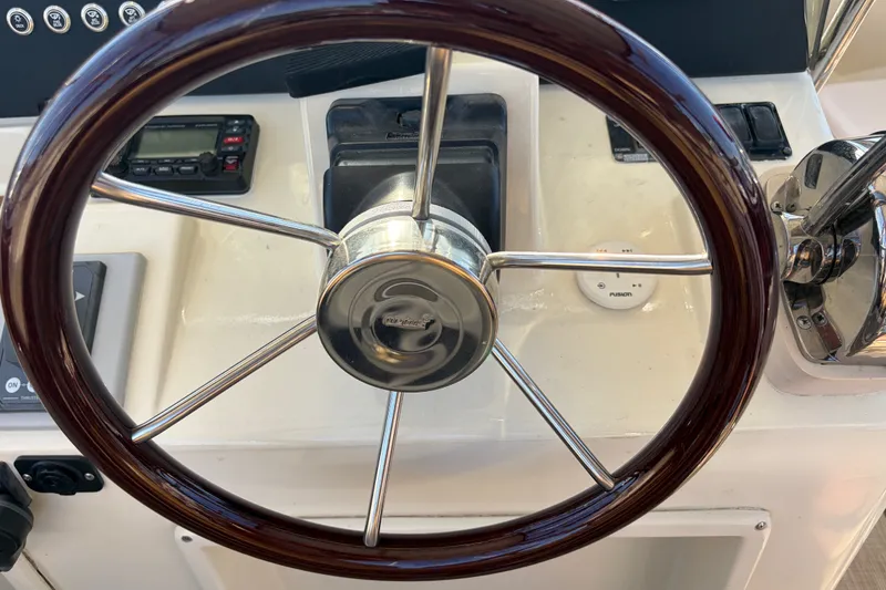 Slide: The Image of Steering wheel of a 2000 Albin 35 Tournament Express boat, featuring wood and metal design. - 58
