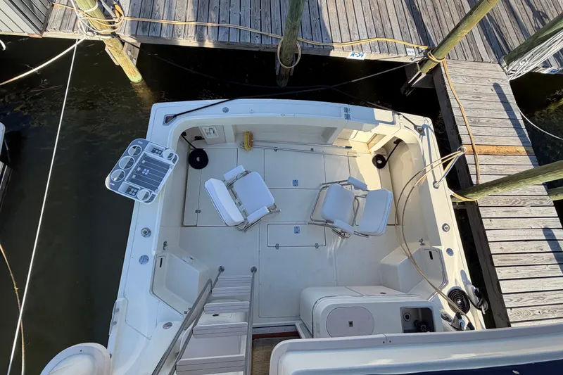 Slide: The Image of 2000 Albin 35 Tournament Express boat docked, featuring spacious deck with chairs and fishing setup. - 60