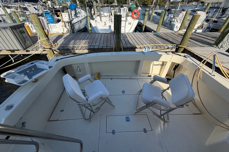 Slide: The Image of Spacious deck of 2000 Albin 35 Tournament Express at marina, featuring folding chairs. - 61