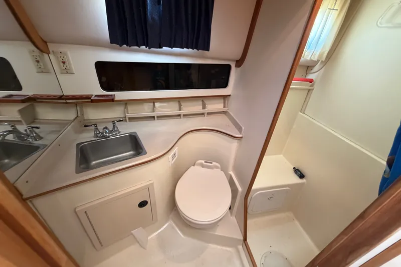 Slide: The Image of 2000 Albin 35 Tournament Express boat bathroom with sink, toilet, and shower area. - 25