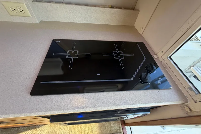 Slide: The Image of Stovetop in 2000 Albin 35 Tournament Express boat kitchen, featuring sleek black design. - 30