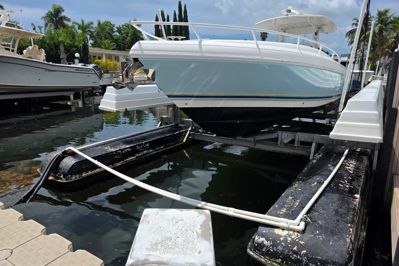 Slide: The Image of 2008 Intrepid 370 Cuddy boat on lift, surrounded by tropical scenery. - 2