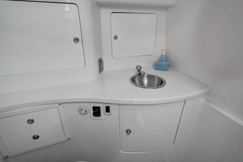 Slide: The Image of 2008 Intrepid 370 Cuddy boat bathroom with sink, storage cabinets, and soap dispenser. - 13