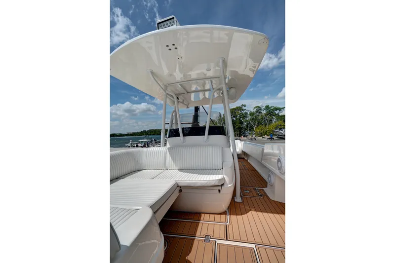 Slide: The Image of 2008 Intrepid 370 Cuddy boat interior with white seating and wooden deck. - 24