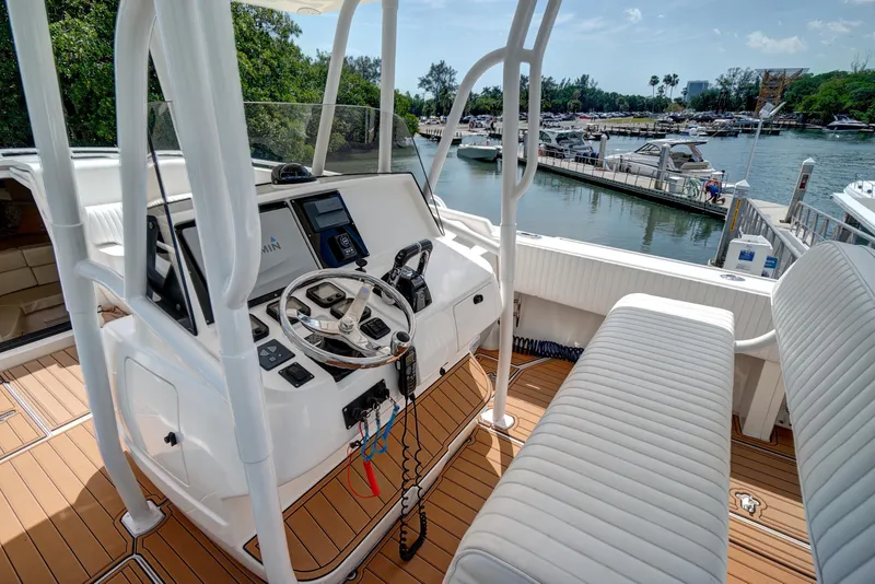 Slide: The Image of 2008 Intrepid 370 Cuddy boat interior with helm, steering wheel, and dock view. - 27