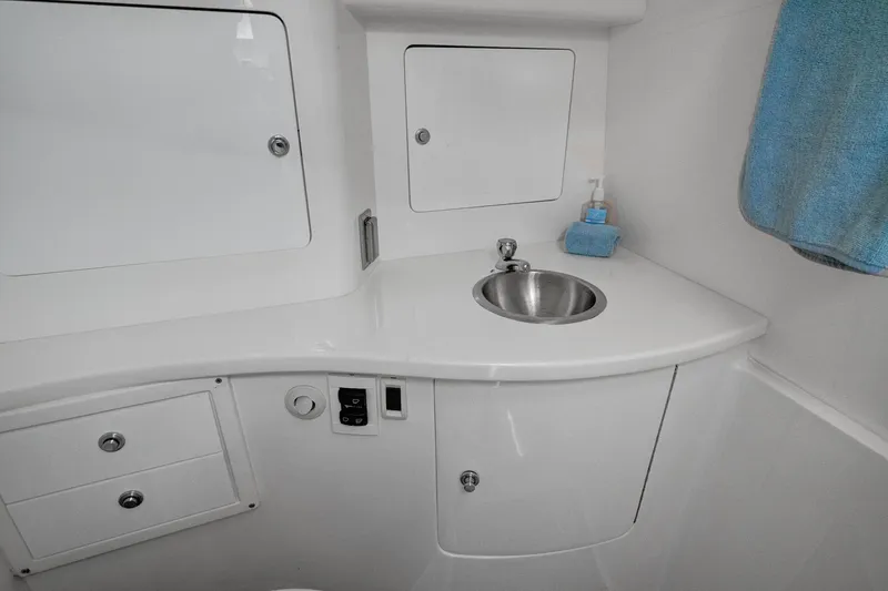 Slide: The Image of 2008 Intrepid 370 Cuddy boat bathroom with sink, storage cabinets, and towel. - 19