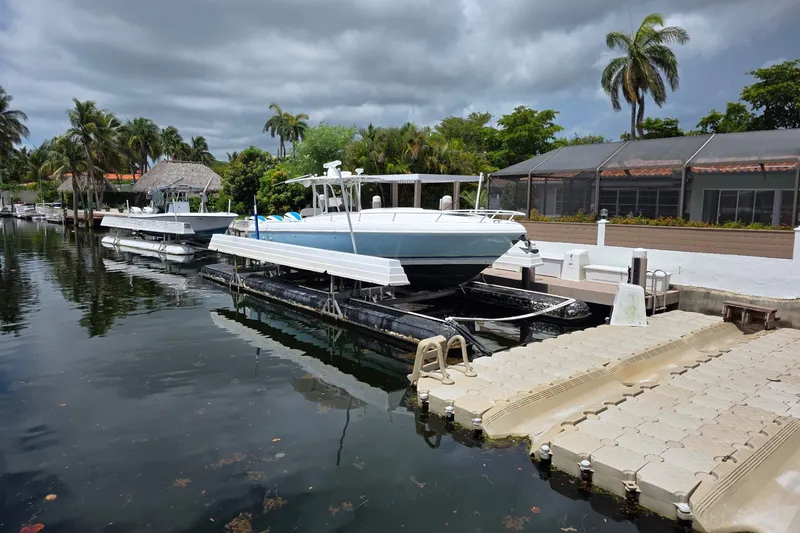 Slide: The Image of 2008 Intrepid 370 Cuddy boat docked in a scenic marina with palm trees. - 4