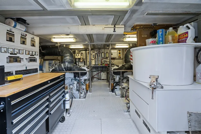 Slide: The Image of Engine room of a 1998 Cheoy Lee Motor Yacht, featuring equipment and storage. - 85
