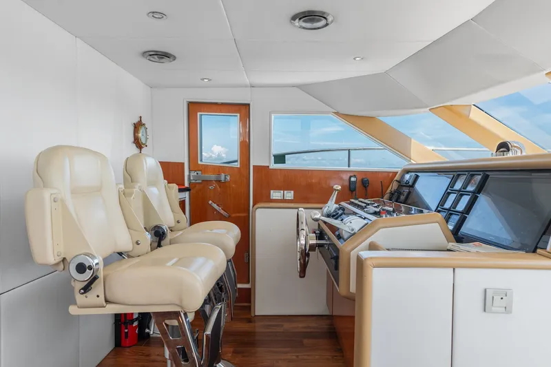 Slide: The Image of Luxurious helm of a 1998 Cheoy Lee Motor Yacht with plush seating and modern controls. - 62