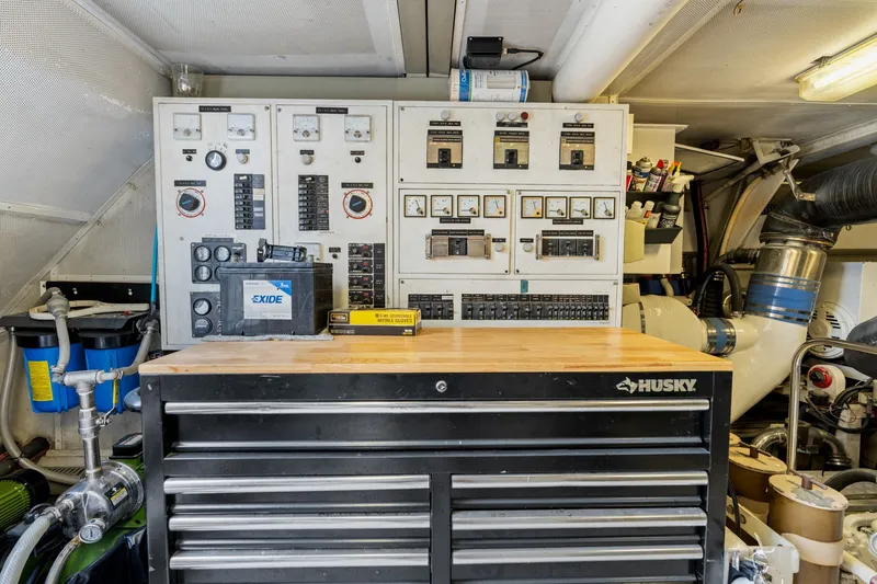 Slide: The Image of Engine room of a 1998 Cheoy Lee Motor Yacht with control panels and tool chest. - 89