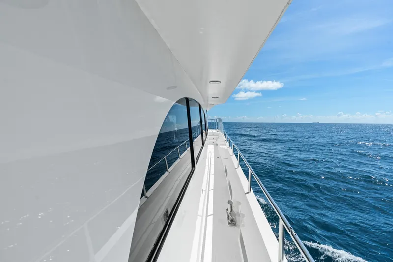 Slide: The Image of Side view of a 1998 Cheoy Lee Motor Yacht cruising on a clear blue ocean. - 76