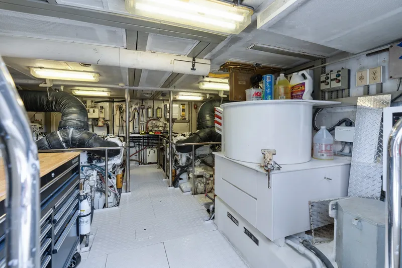 Slide: The Image of Engine room of a 1998 Cheoy Lee Motor Yacht, featuring equipment and storage. - 86
