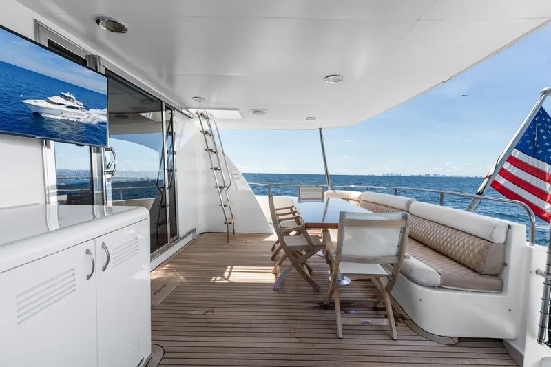 Slide: The Image of Luxurious 1998 Cheoy Lee Motor Yacht deck with seating, ocean view, and American flag. - 69