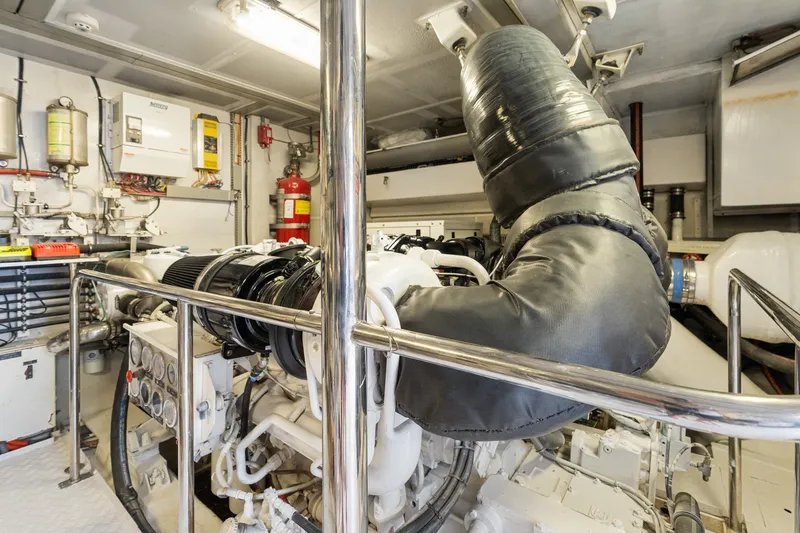 Slide: The Image of Engine room of a 1998 Cheoy Lee Motor Yacht, featuring complex machinery and safety equipment. - 88