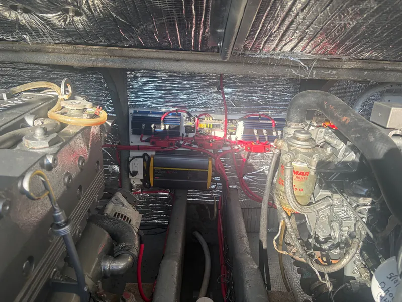 Slide: The Image of The engine room of a 1999 Carolina Classic 28 boat with two engines and wiring. - 16