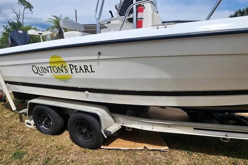 The Image of A 1998 CEB Century boat named "Quinton's Pearl" on a trailer, with a visible fire extinguisher. - 0