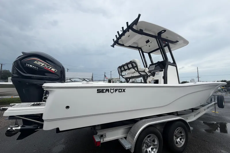 The Image of 2025 Sea Fox 251 Bay Fox boat on trailer, featuring Yamaha engine, under cloudy sky. - 0