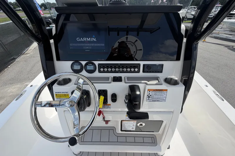Slide: The Image of 2025 Sea Fox 251 Bay Fox boat dashboard with Garmin navigation system and steering wheel. - 23