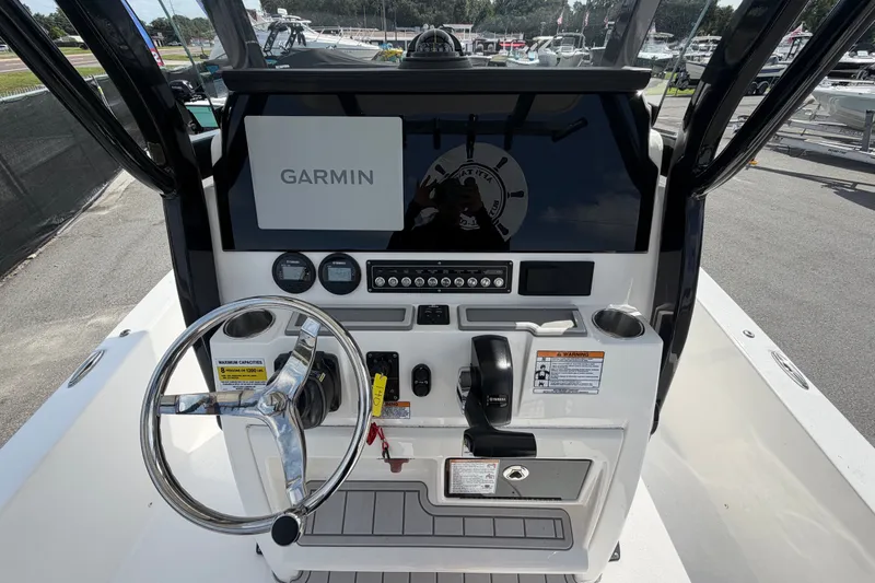 Slide: The Image of 2025 Sea Fox 251 Bay Fox boat dashboard with Garmin navigation system and steering wheel. - 22