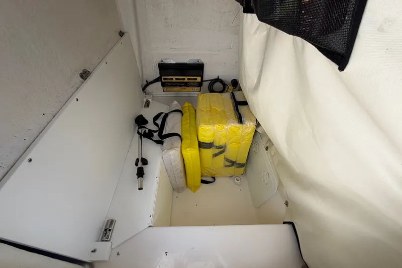 Slide: The Image of Storage compartment in 2025 Sea Fox 251 Bay Fox with life jackets and battery charger. - 37