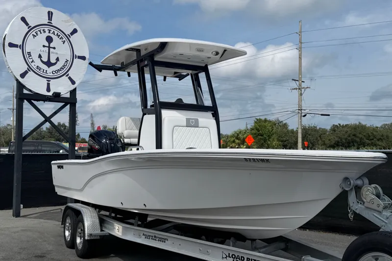 The Image of 2025 Sea Fox 251 Bay Fox boat on trailer at dealership, clear sky background. - 0