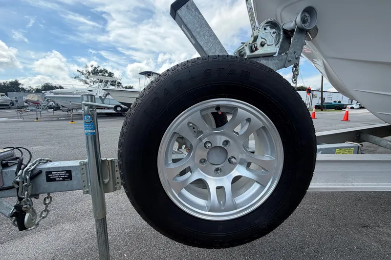 Slide: The Image of Trailer wheel of 2025 Sea Fox 251 Bay Fox boat in a parking lot. - 85