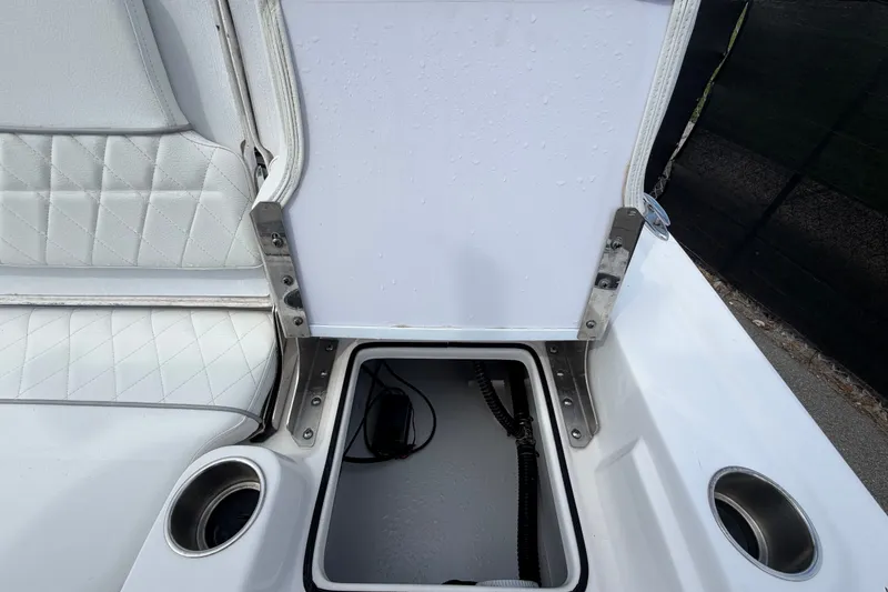 Slide: The Image of 2025 Sea Fox 251 Bay Fox boat storage compartment with cup holders and cushioned seating. - 74