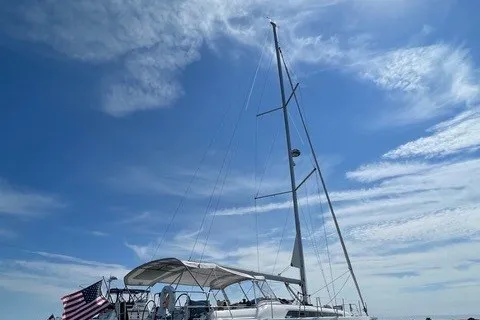 Slide: The Image of 2021 Beneteau Oceanis 40.1 sailboat under a clear blue sky with American flag. - 6