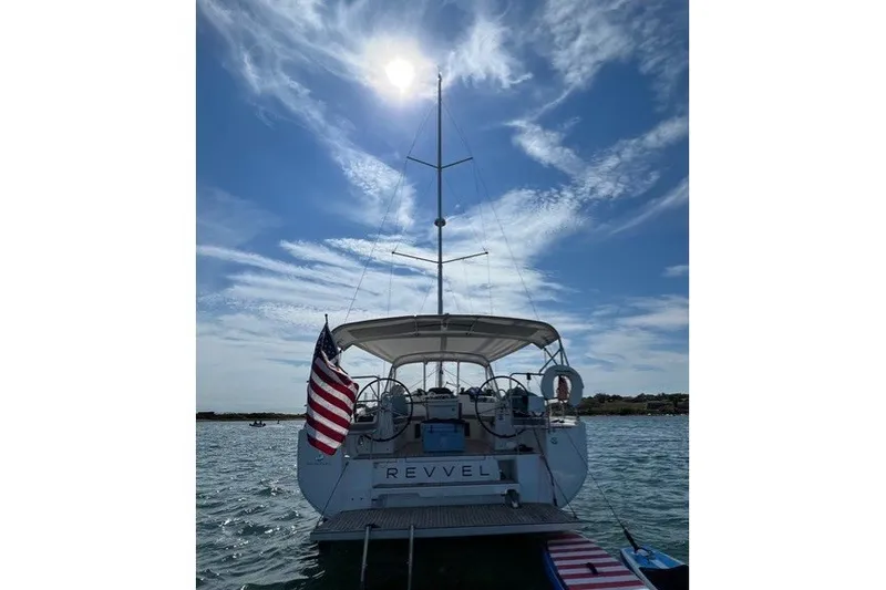 Slide: The Image of 2021 Beneteau Oceanis 40.1 sailboat with American flag, under sunny sky. - 2