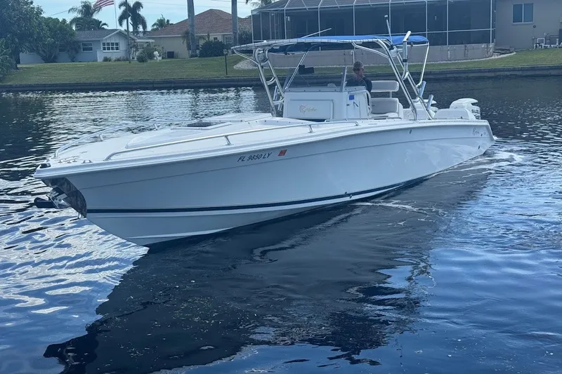 Slide: The Image of 2003 Marlago 35 FS boat cruising on a calm waterway near residential area. - 4