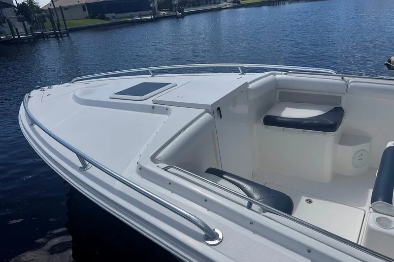 Slide: The Image of 2003 Marlago 35 FS boat with sleek white deck and seating, docked on calm water. - 13