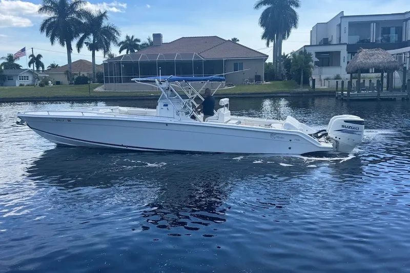 Slide: The Image of 2003 Marlago 35 FS boat cruising on a calm waterway near waterfront homes. - 8