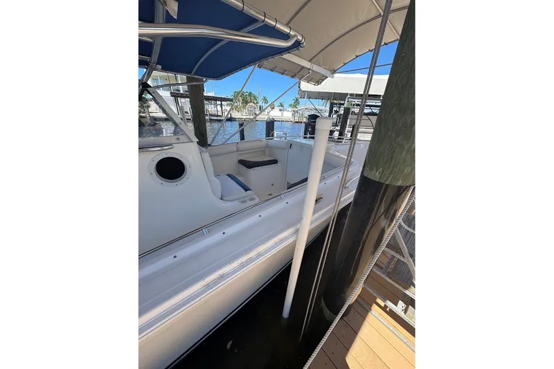 Slide: The Image of 2003 Marlago 35 FS boat docked with blue canopy and white interior. - 19