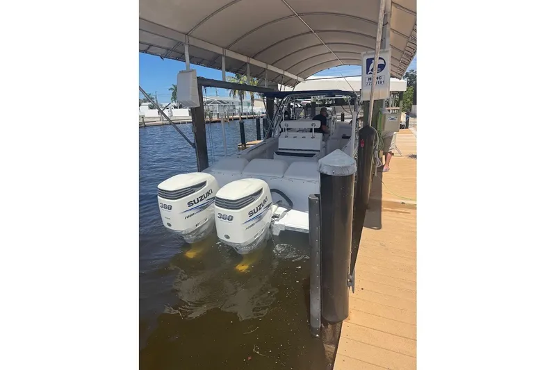 Slide: The Image of 2003 Marlago 35 FS boat with twin Suzuki 300 engines docked under a canopy. - 21