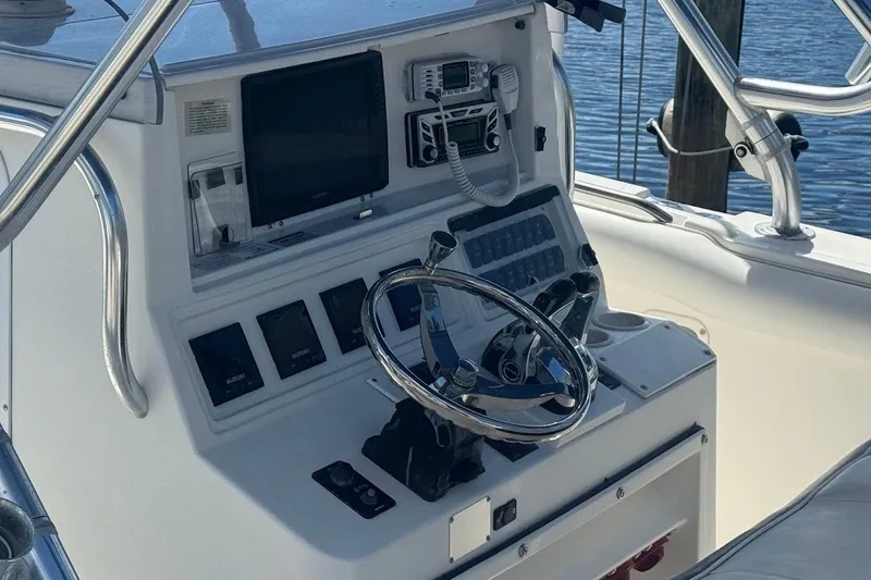 Slide: The Image of Console of a 2003 Marlago 35 FS boat with steering wheel and navigation equipment. - 18