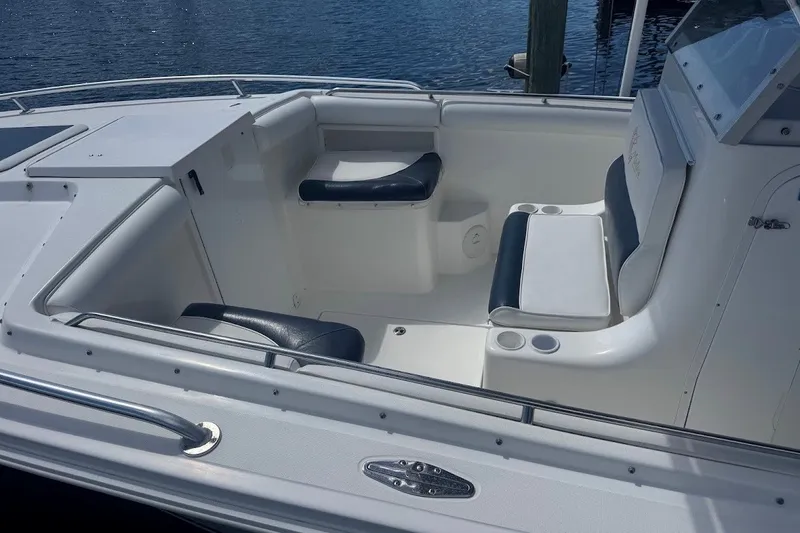 Slide: The Image of 2003 Marlago 35 FS boat interior with seating and cup holders, docked by the water. - 14