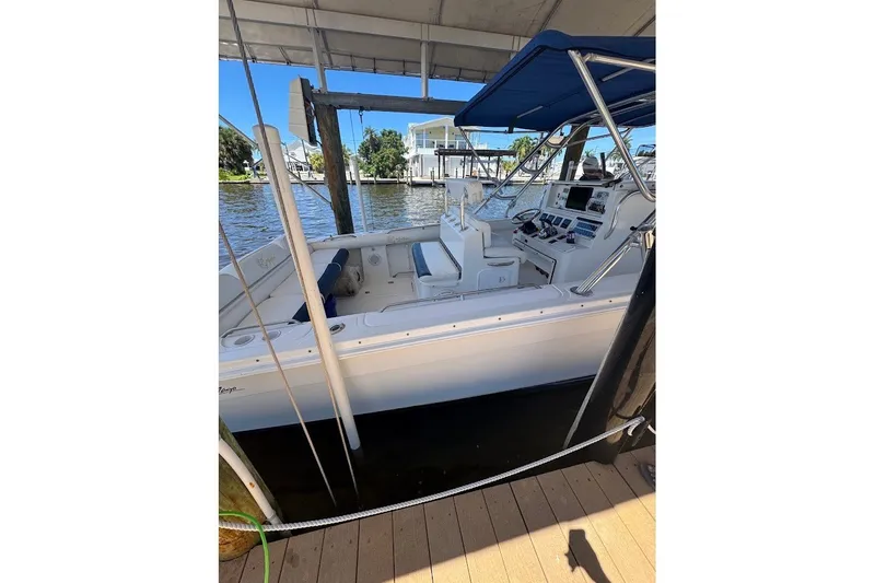 Slide: The Image of 2003 Marlago 35 FS boat docked under a canopy, featuring a spacious cockpit. - 20