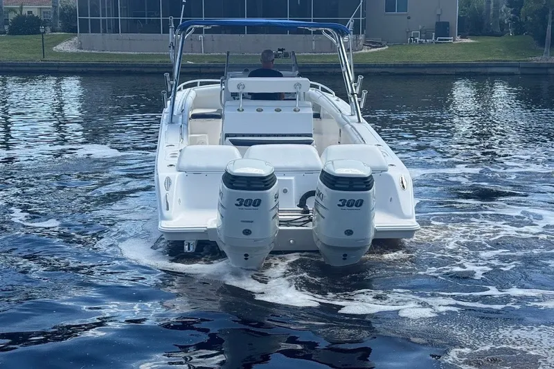 Slide: The Image of 2003 Marlago 35 FS boat with dual 300 horsepower engines on a calm waterway. - 10