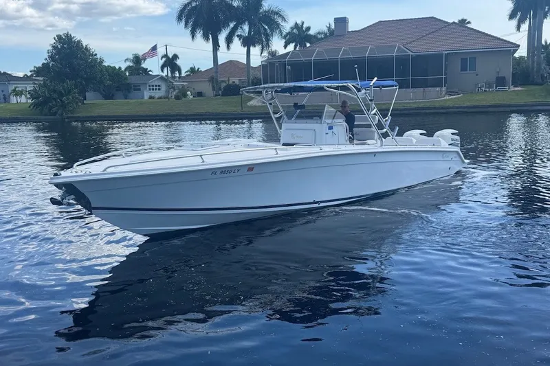 Slide: The Image of 2003 Marlago 35 FS boat cruising on a calm waterway near waterfront homes. - 5