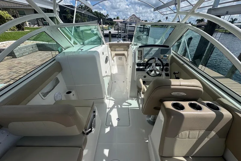 Slide: The Image of 2020 Sailfish 245 DC boat interior with beige seating and modern dashboard. - 20
