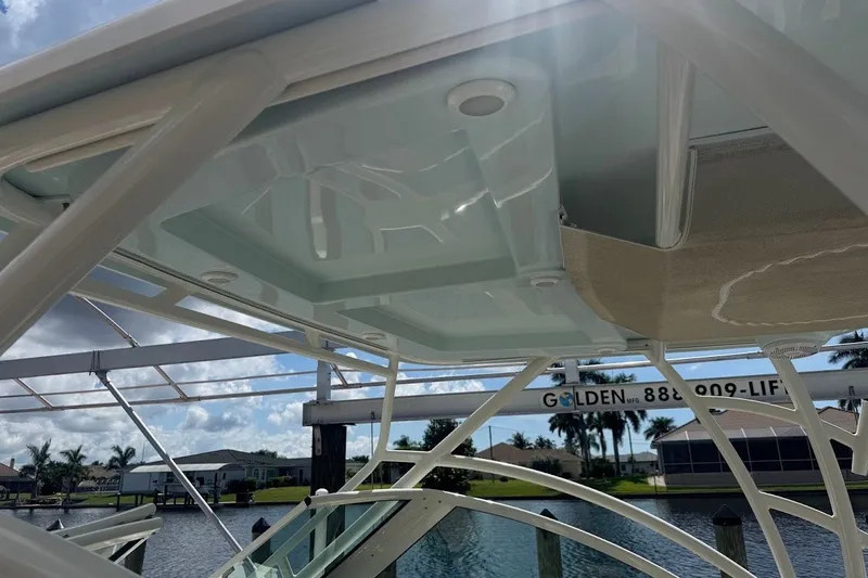 Slide: The Image of 2020 Sailfish 245 DC boat canopy with clear sky and waterfront view. - 16