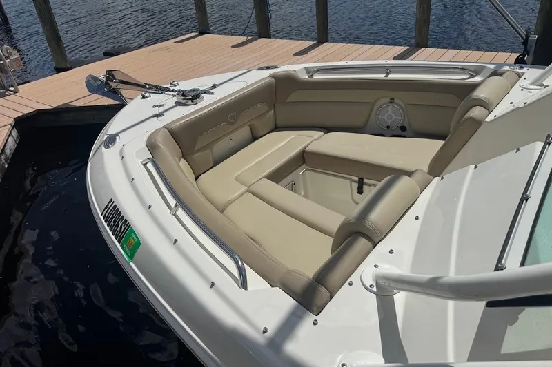 Slide: The Image of 2020 Sailfish 245 DC boat with beige seating, docked by the water. - 13
