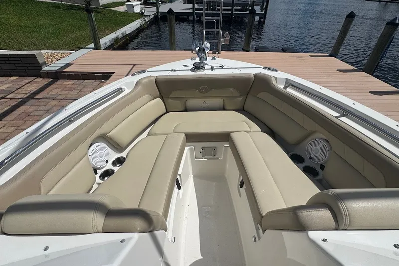 Slide: The Image of 2020 Sailfish 245 DC boat interior with beige seating and cup holders at dockside. - 14