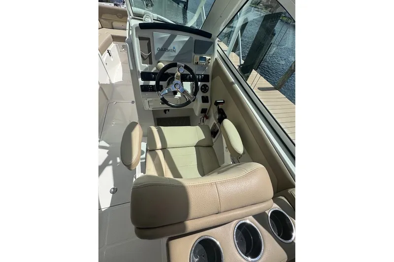 Slide: The Image of 2020 Sailfish 245 DC boat interior with steering wheel and Garmin navigation system. - 17