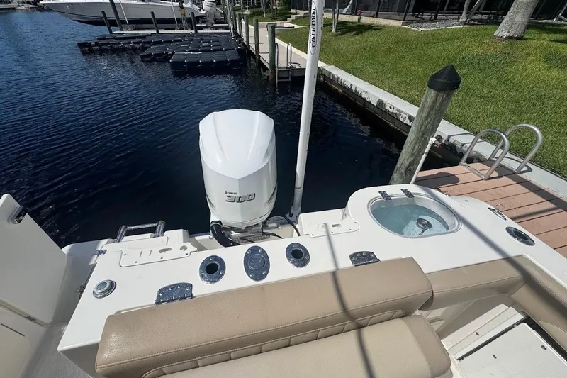 Slide: The Image of 2020 Sailfish 245 DC boat with Yamaha 300 engine docked by the water. - 26