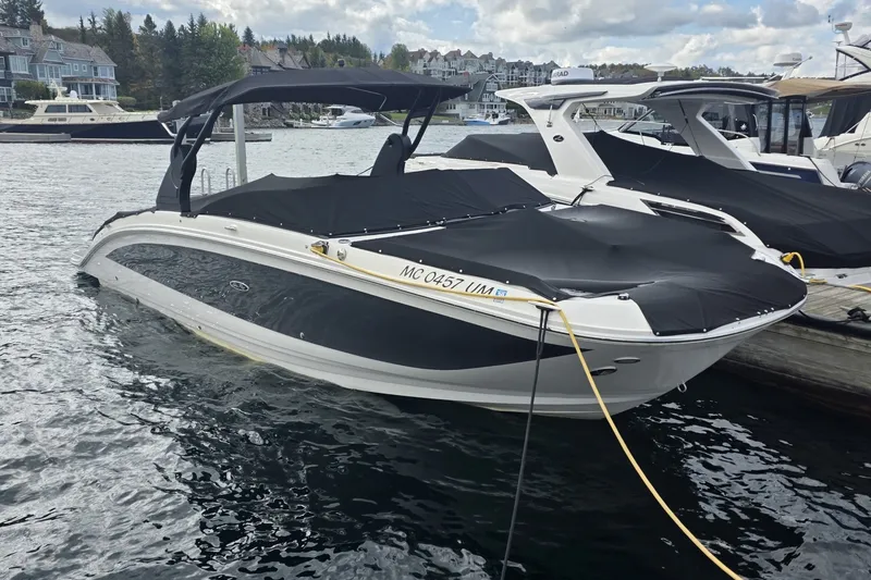 Slide: The Image of 2020 Sea Ray SDX 290 boat docked in a marina, covered and ready for use. - 6