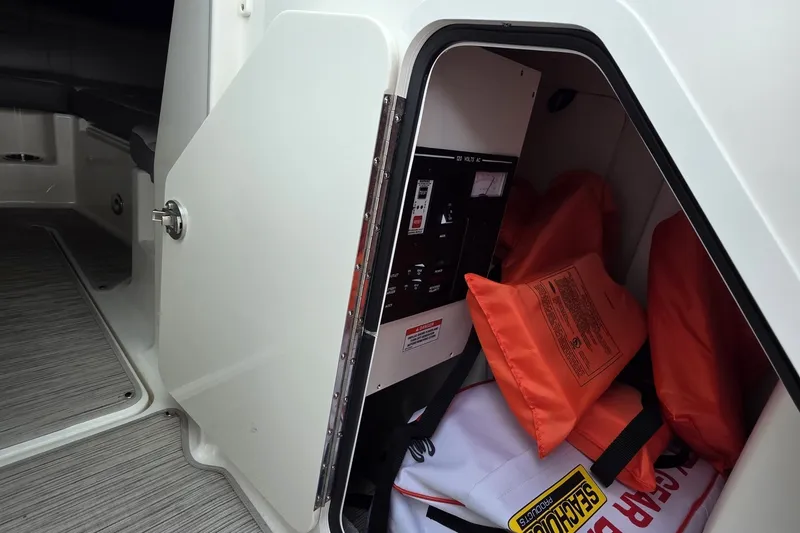 Slide: The Image of Storage compartment on a 2020 Sea Ray SDX 290 boat with life jackets and safety equipment. - 9