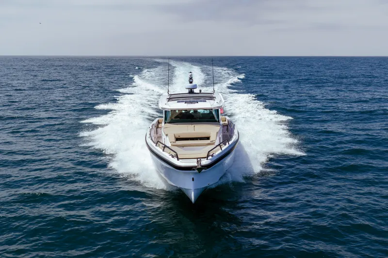 Slide: The Image of 2027 Axopar 38 XC Cross Cabin cruising on open sea, creating a dynamic wake. - 2