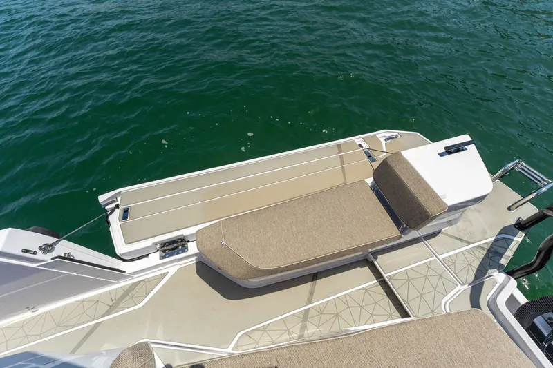 Slide: The Image of 2027 Axopar 38 XC Cross Cabin boat deck with seating, overlooking calm water. - 14